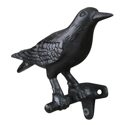 A black cast iron raven figurine perched on a branch, shown against a plain white background.