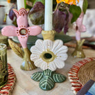 Decorative ceramic candle holder with floral design on a table with other decorative items.