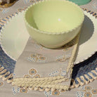 Light green bowl on a decorative tablecloth with floral patterns