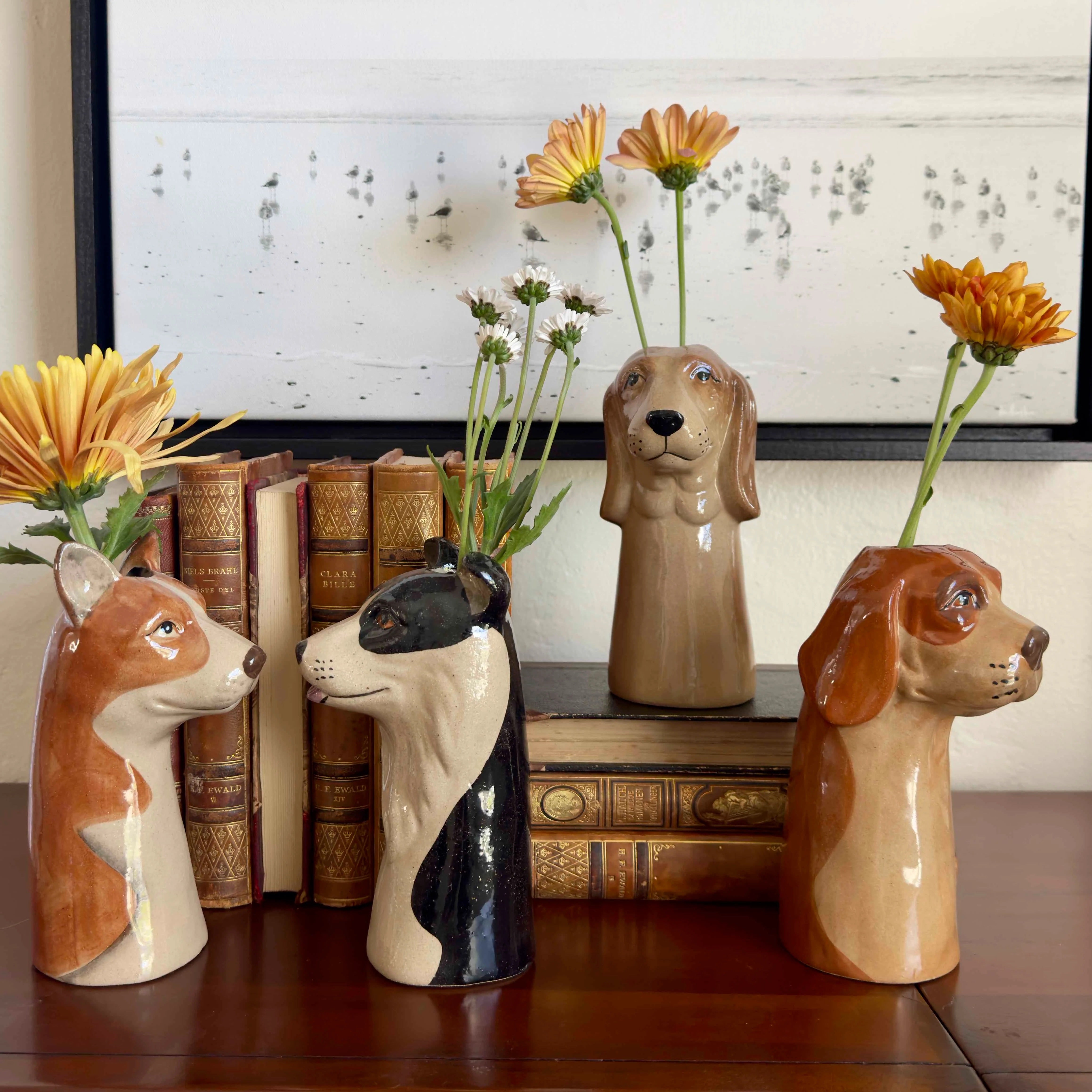 Dog-shaped vases with flowers on a wooden surface