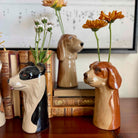 Dog-shaped vases with flowers on a wooden surface