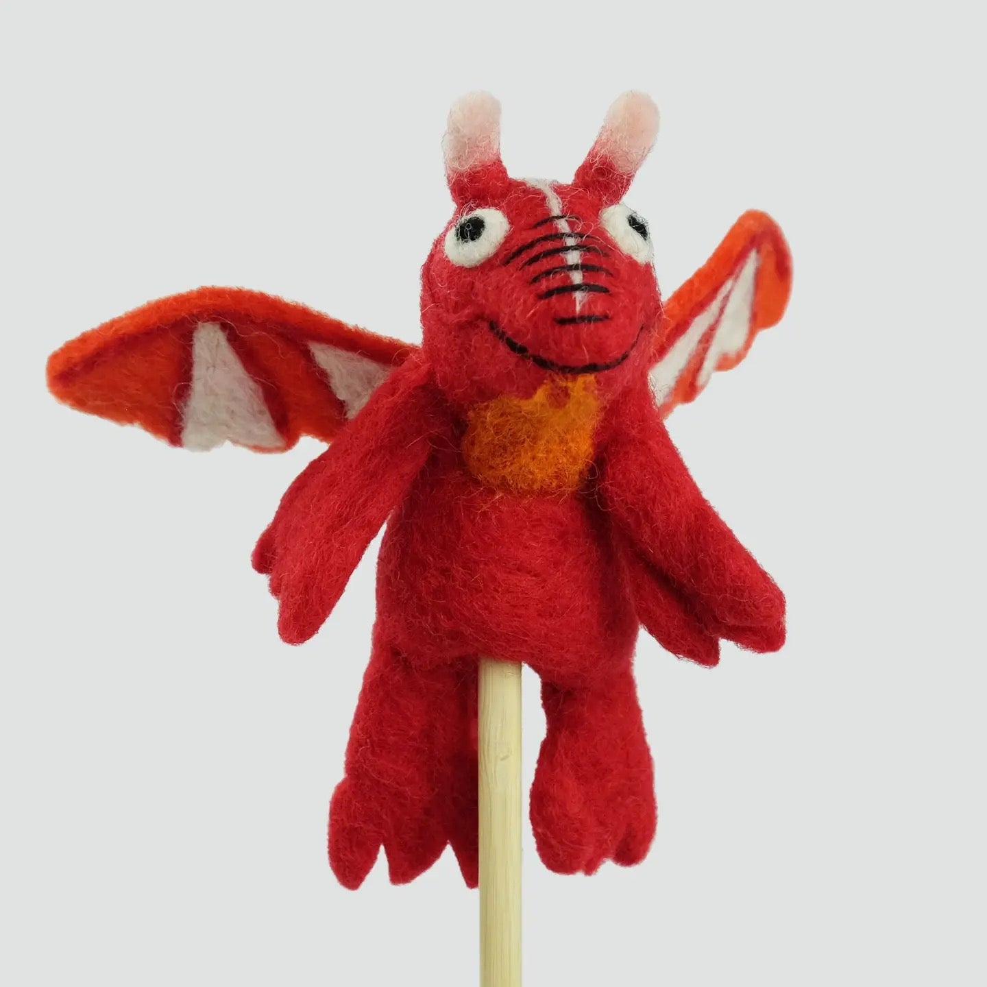 Red dragon plush toy on a stick against a white background