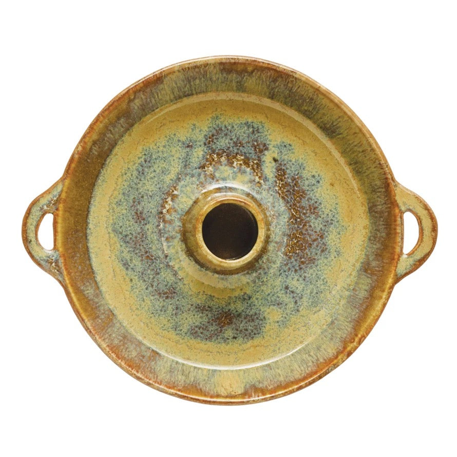 Round ceramic dish with handles on a white background