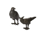 Two metal bird figurines on a white background