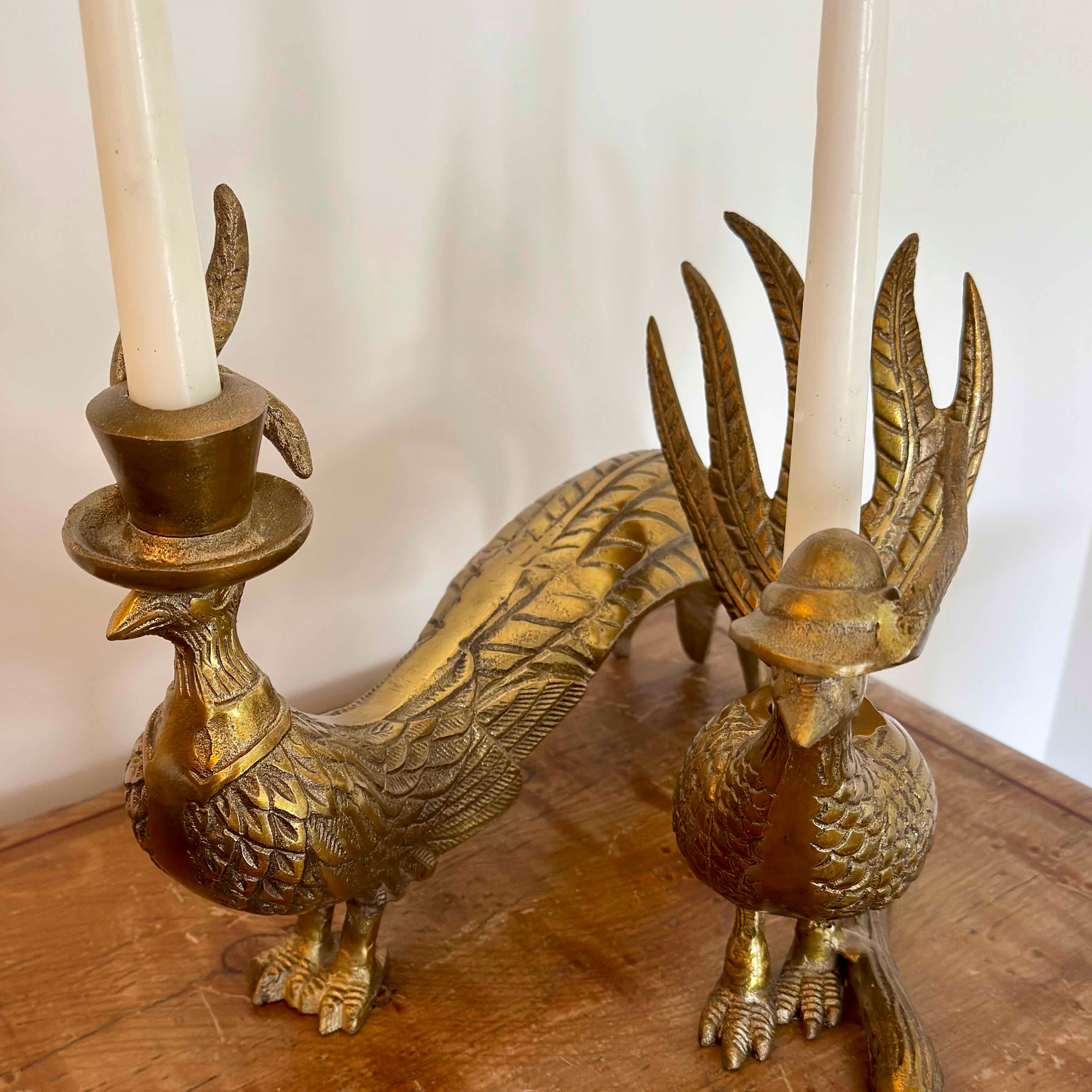 Brass peacock-shaped candle holder with candles on a wooden surface.