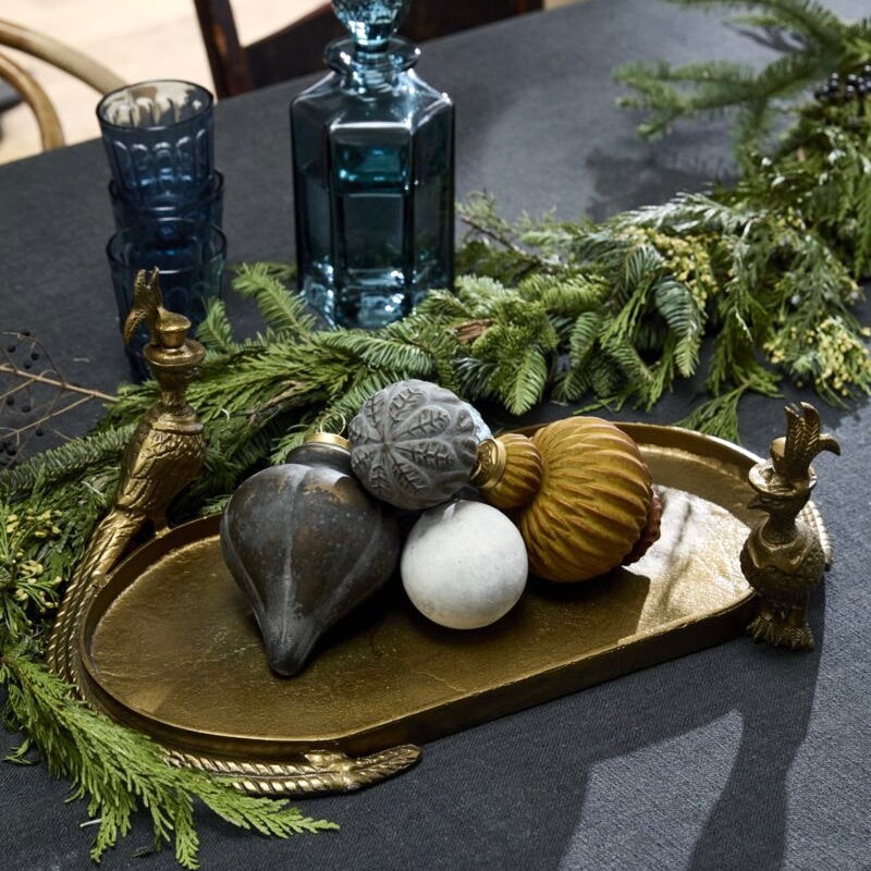 Decorative tray with ornaments on a table with greenery