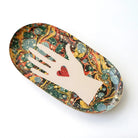 Decorative tray with marbled design and hand silhouette holding a heart on a white background