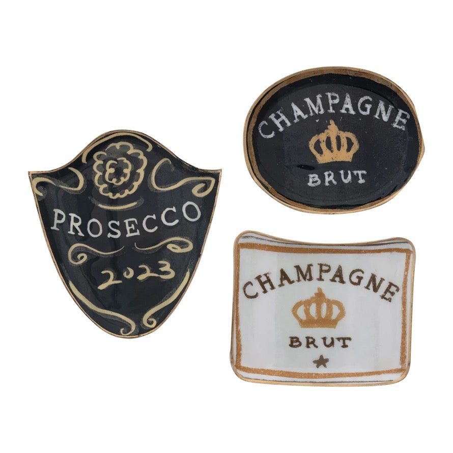 Three decorative plates with 'Prosecco 2023' and 'Champagne Brut' designs on a white background.