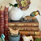Decorative setup with books, a vase, and small figurines on a surface.