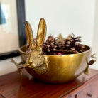 Gold rabbit-shaped bowl with decorative elements on a wooden surface