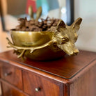Gold fox-shaped bowl on a wooden surface with blurred background