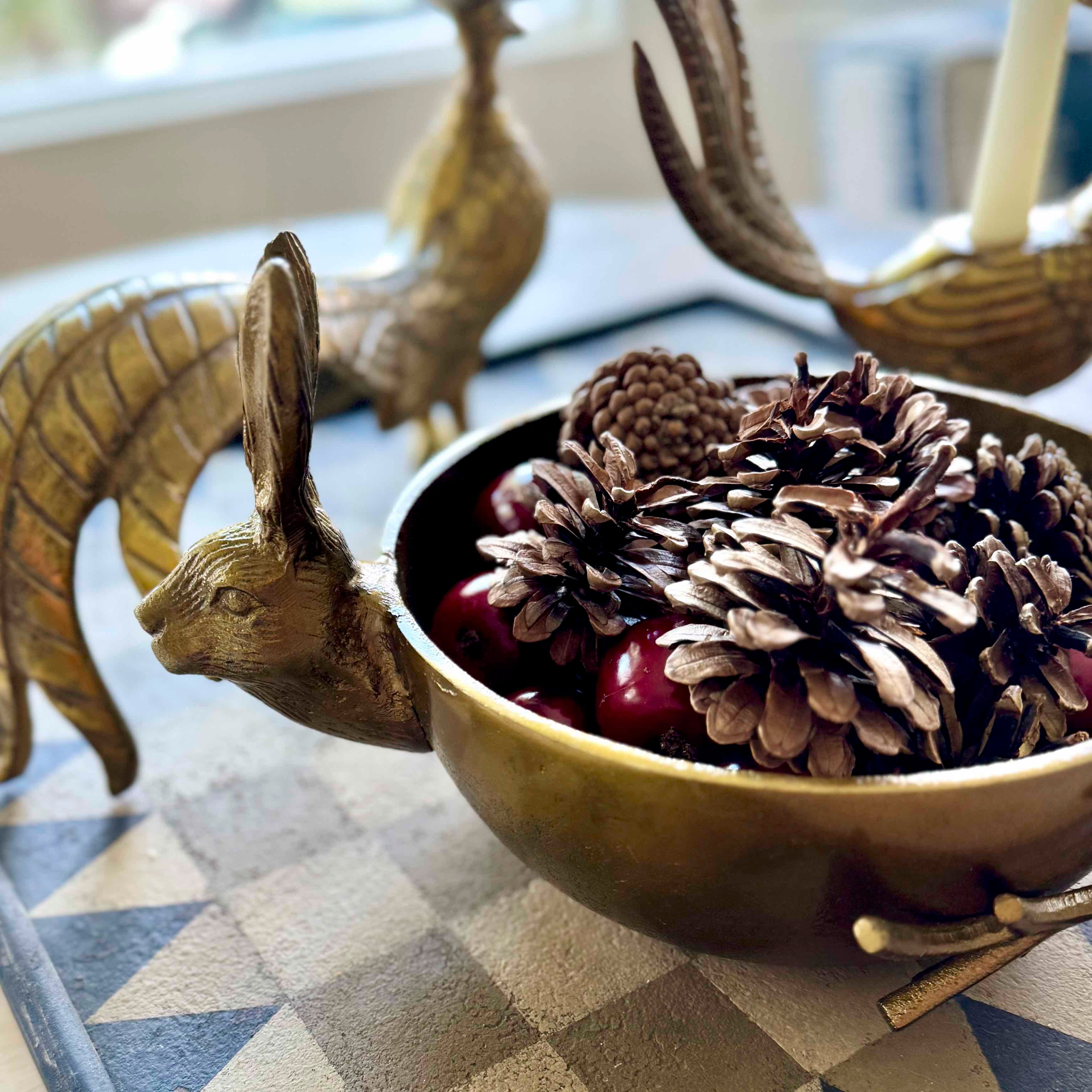 Decorative bowl with pinecones and berries on a checkered tablecloth
