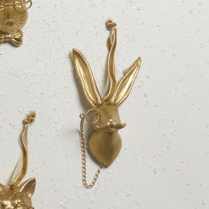 Gold rabbit-shaped keychain on a light gray background