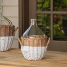 Wicker basket with a glass bottle on a wooden surface outdoors