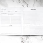 Blank recipe card with sections for title, time, ingredients, directions, and notes on a marble surface.
