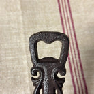 Decorative black bottle opener on a textured fabric background