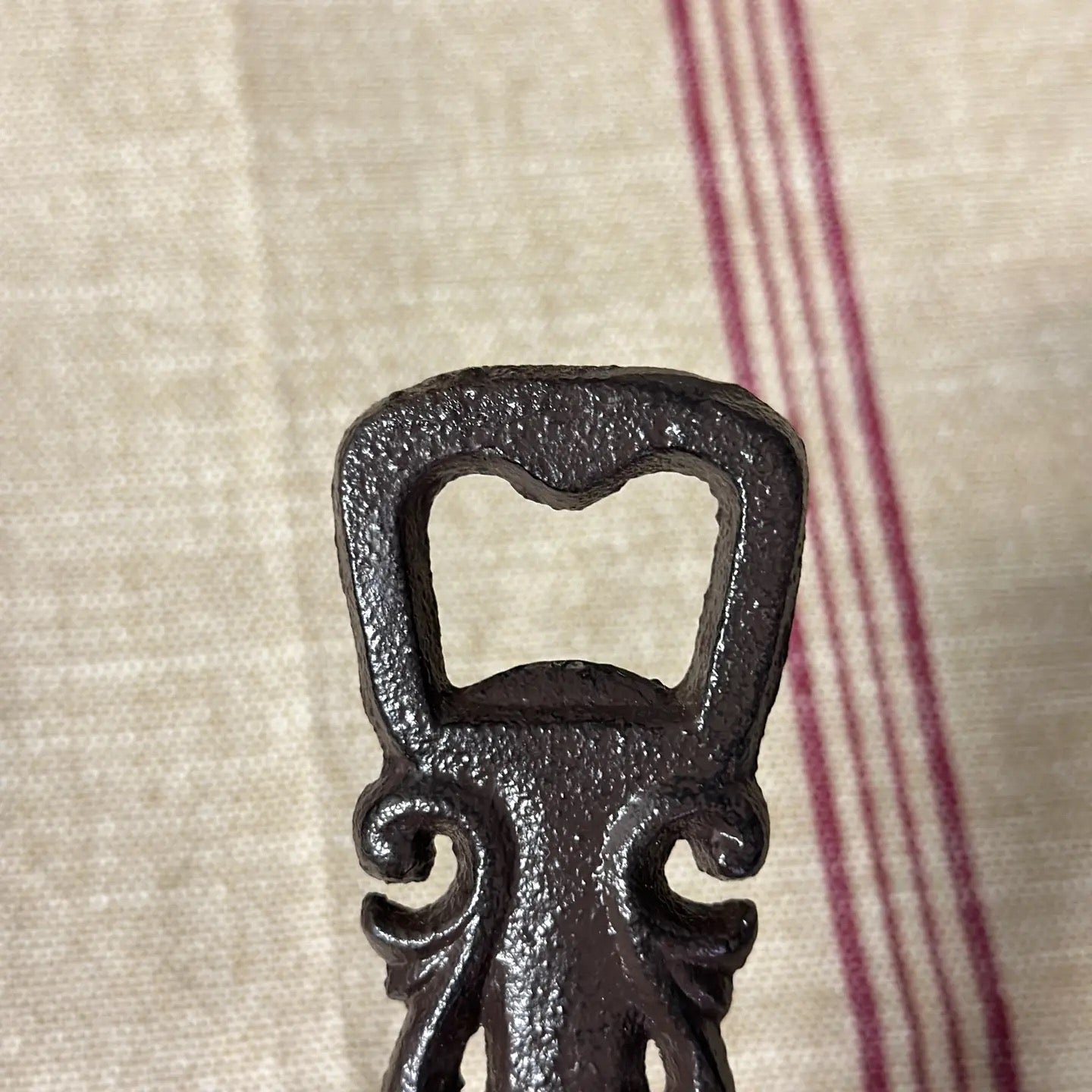 Decorative black bottle opener on a textured fabric background