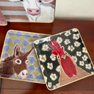 Set of decorative trays with animal illustrations on a wooden surface