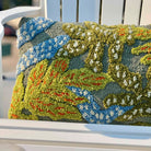 Decorative pillow with nature-themed pattern on a white chair