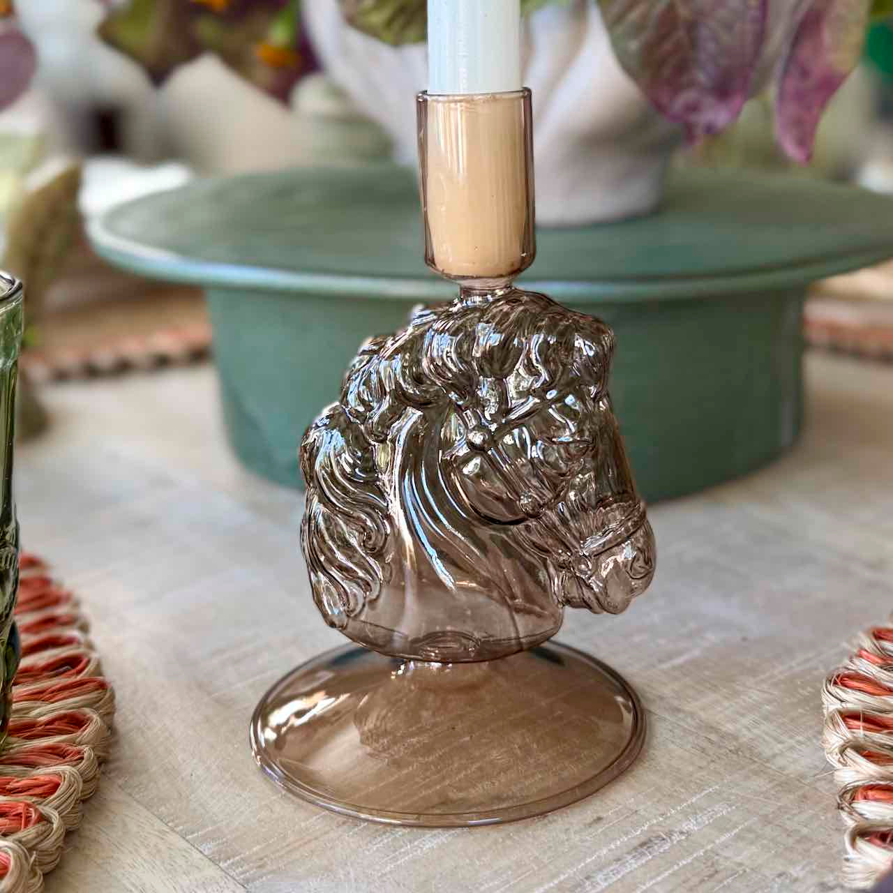 Decorative candle holder with horse head design on a table.