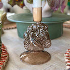 Decorative candle holder with horse head design on a table.