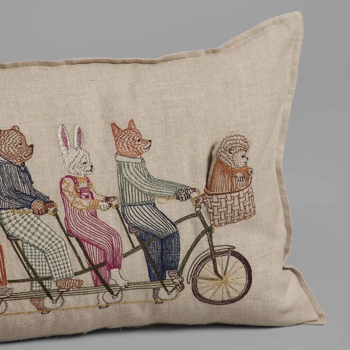 Decorative pillow with embroidered design of animals on a bicycle