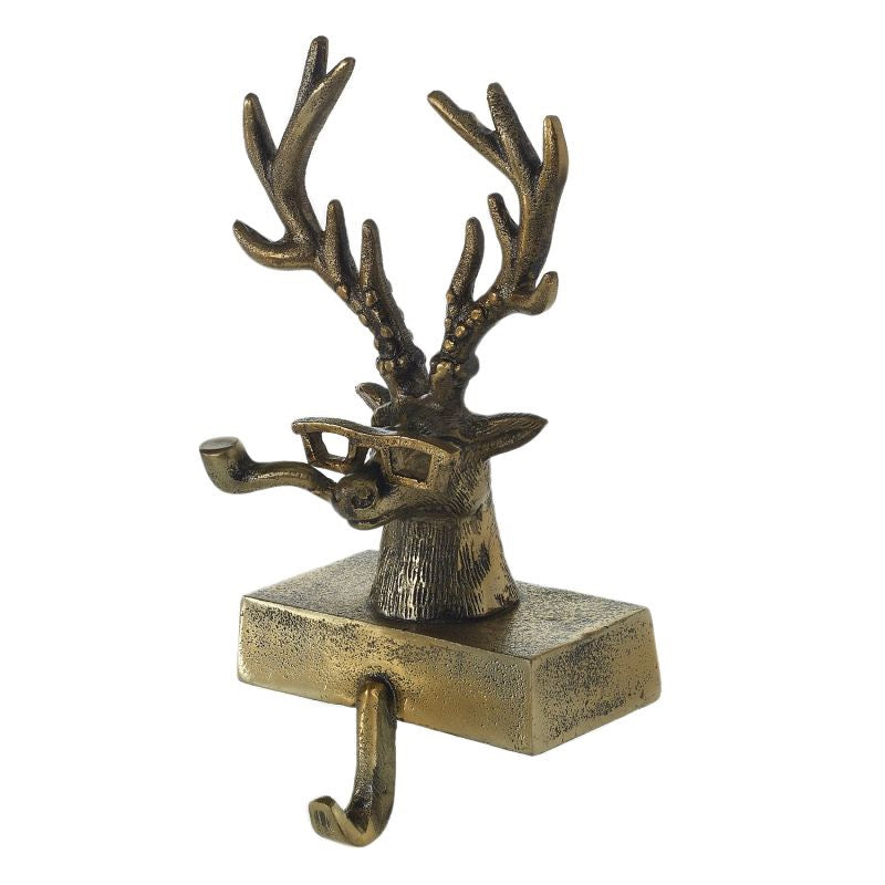 A metal stocking holder in the shape of a stag with an antique gold finish.
