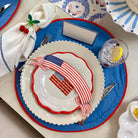 Dinner table setting with American flag-themed plates and napkins.