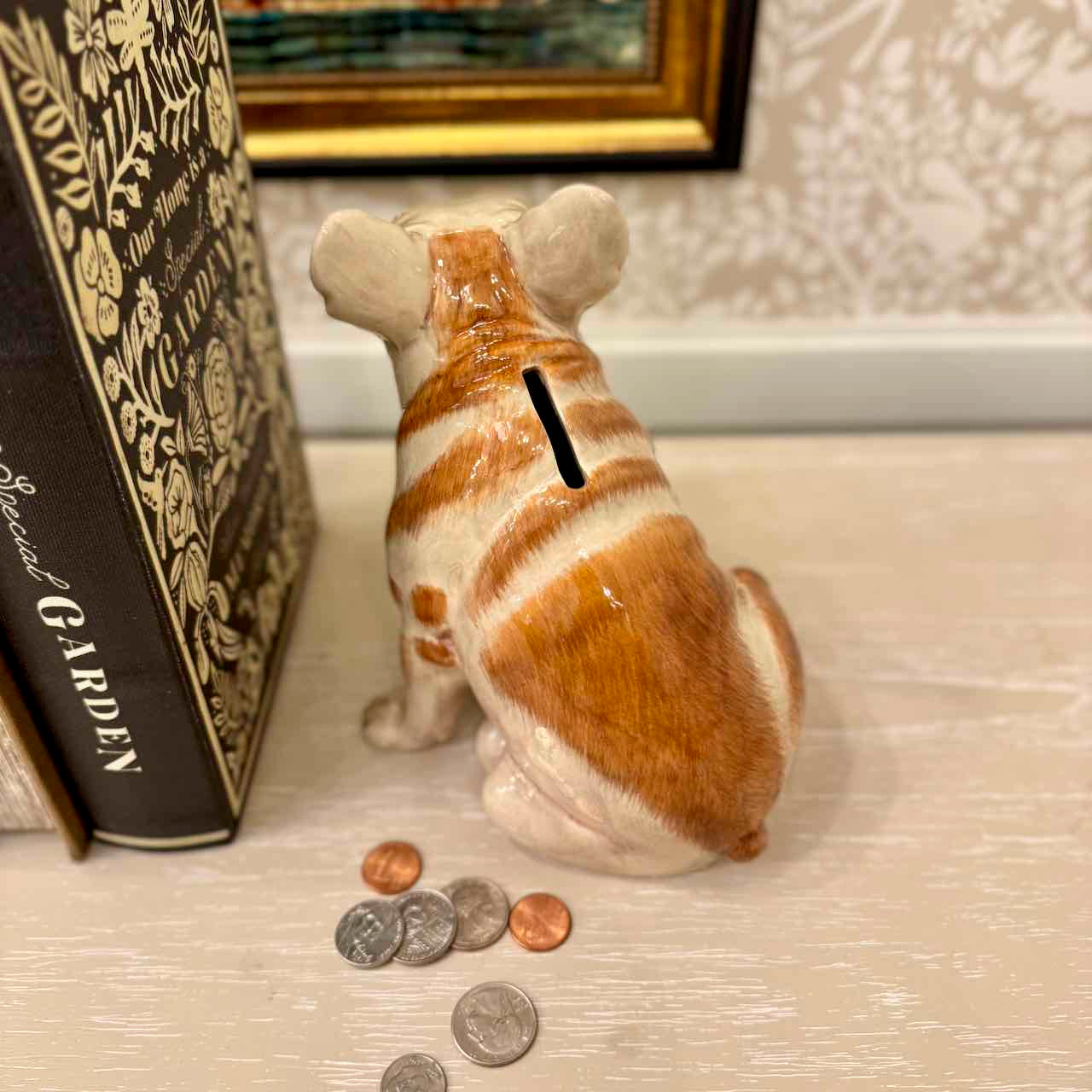 Dog-shaped piggy bank with coins on a surface