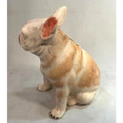 Ceramic sculpture of a dog on a plain background