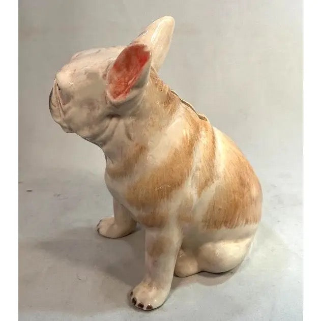 Ceramic sculpture of a dog on a plain background