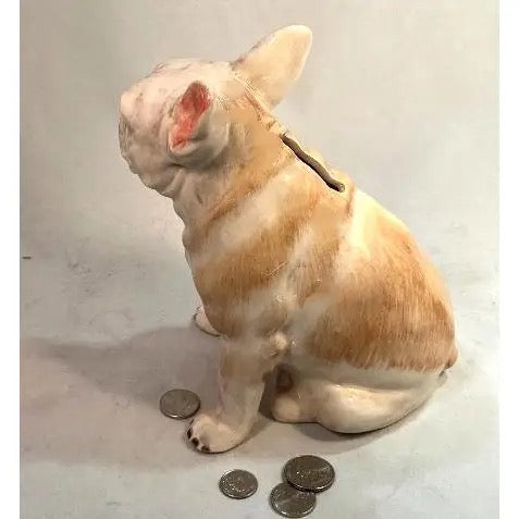 Dog-shaped piggy bank with coins on a plain background