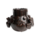 Decorative dark brown vase with floral and heart designs on a white background