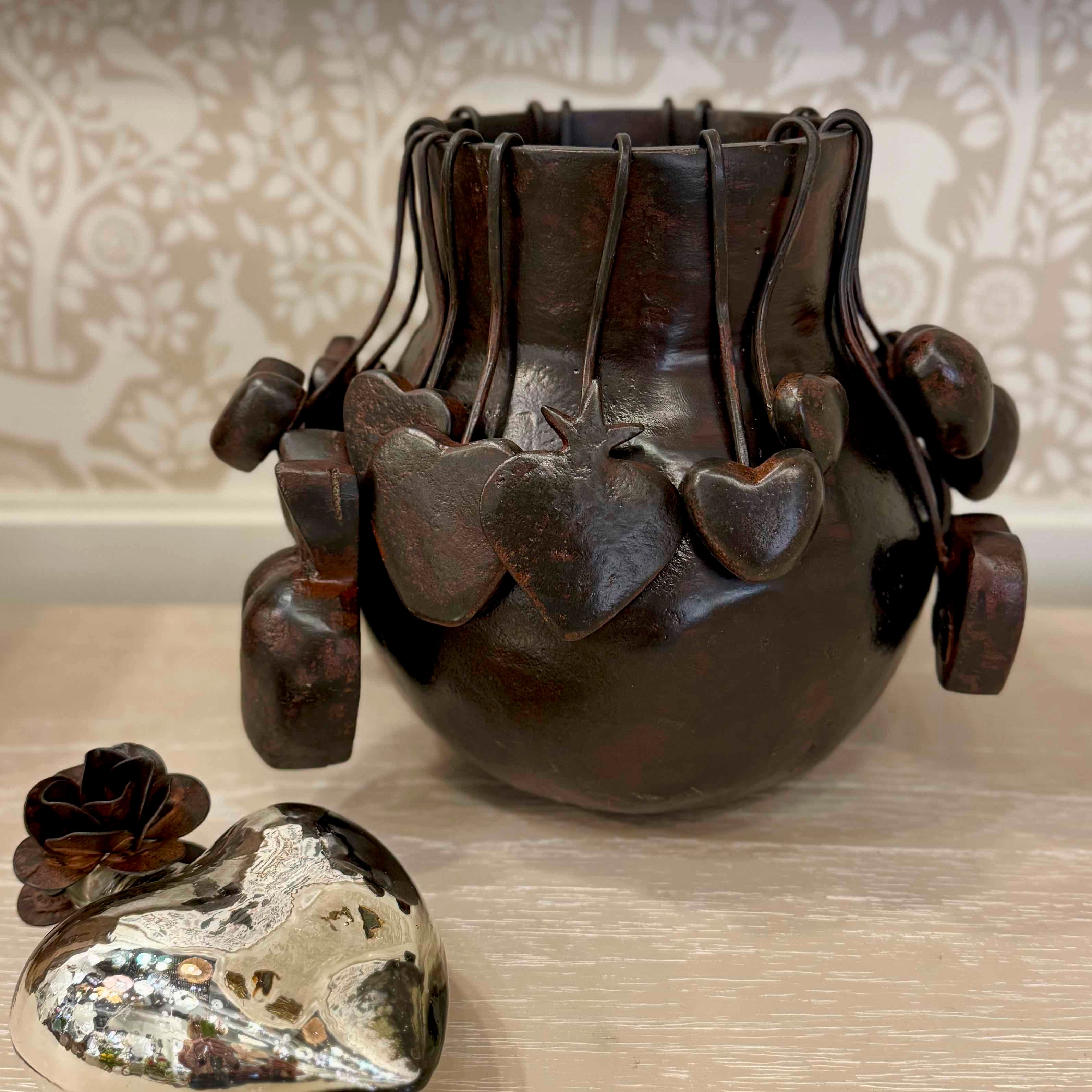 Decorative vase with heart-shaped elements on a textured surface