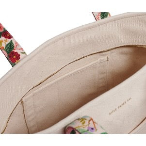 Close-up of a beige handbag with floral patterns on a white background
