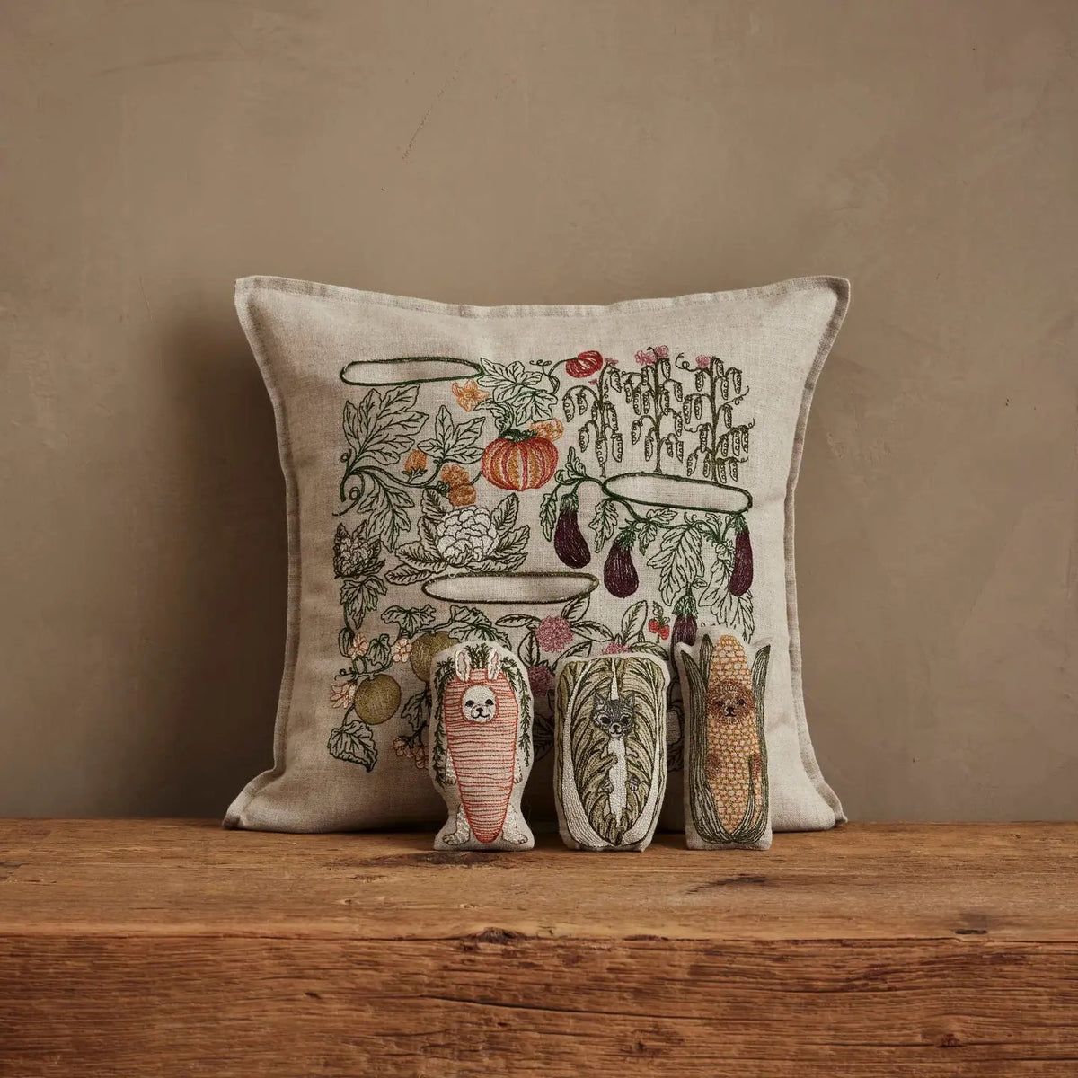 Decorative pillow with a nature-themed design on a wooden surface against a brown background