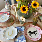 Decorative table setting with horse-themed plates and sunflowers.