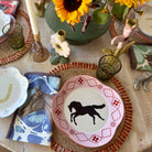 Decorative table setting with horse-themed plates and sunflowers.