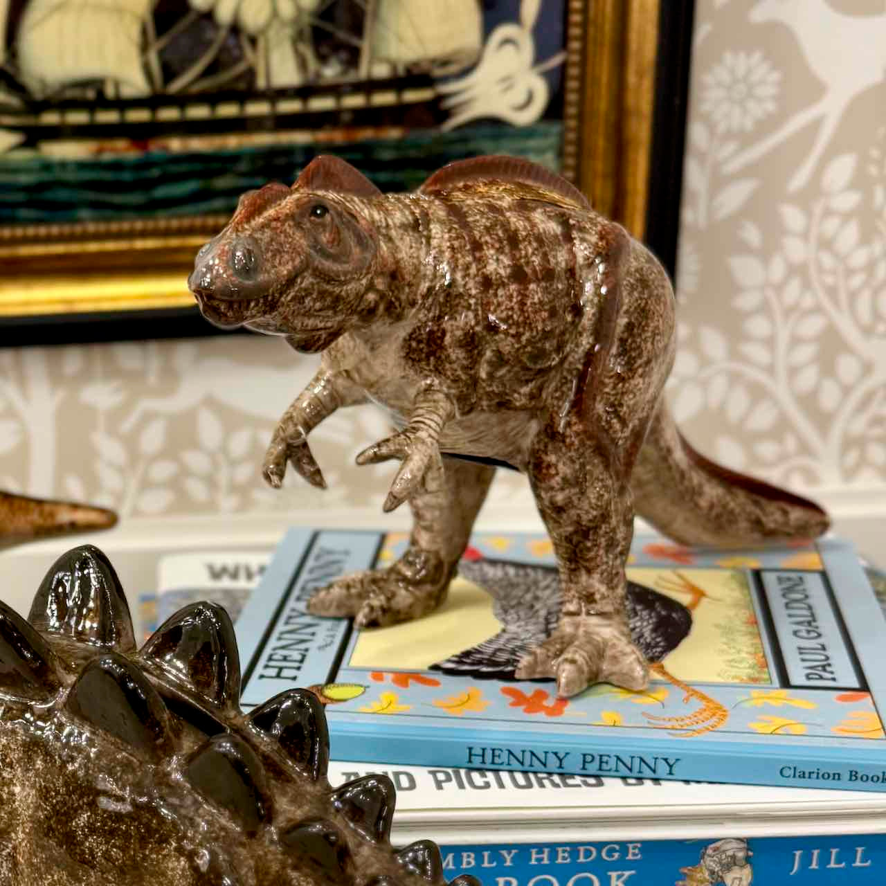 Model of a dinosaur standing on books with a decorative background