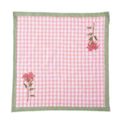Pink checkered towel with floral designs on a white background