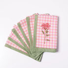 Set of pink checkered napkins with floral embroidery on a white background