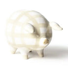 White ceramic piggy bank with black polka dots on a white background