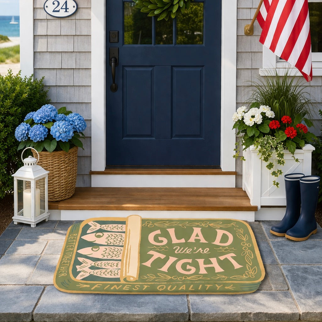 Front door of a house with a decorative doormat, boots, and plants.