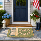 Front door of a house with a decorative doormat, boots, and plants.