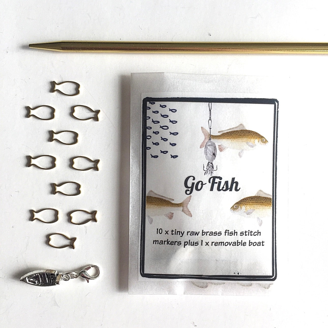 Set of fishing-themed knitting stitch markers with packaging on a white background