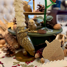 Decorative owl figurine with a tree on a table with autumn-themed items.