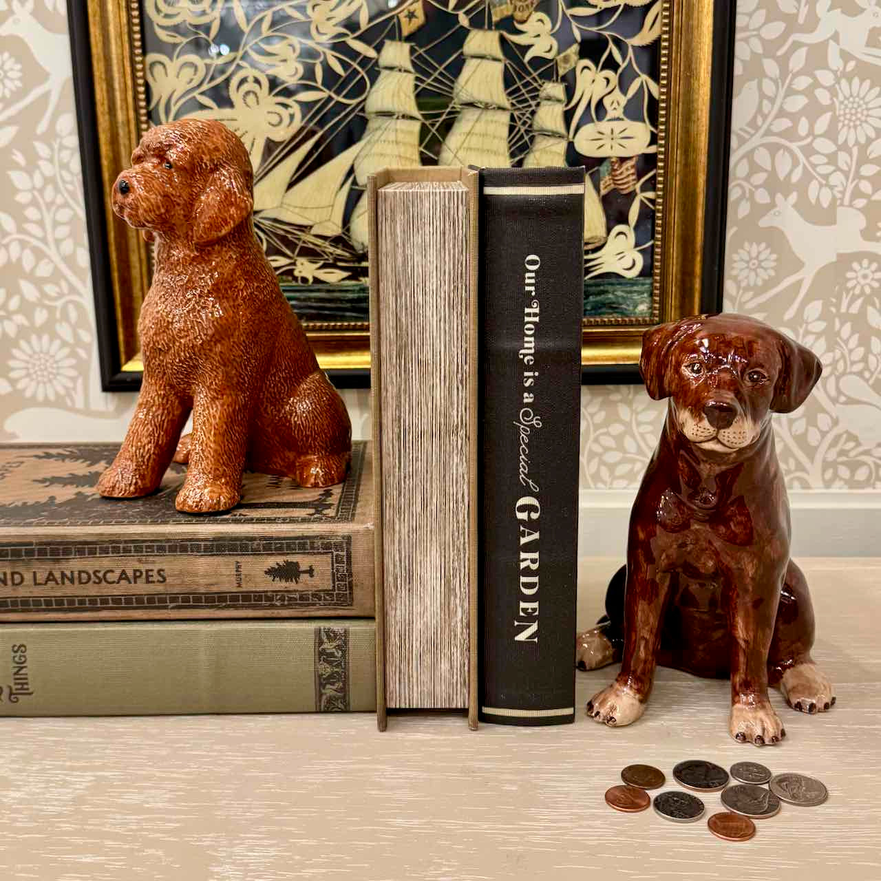 Two ceramic dog figurines on books with a decorative background