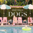 Book cover of 'DOGS' by Gray Malin featuring dogs around a pool with umbrellas and chairs.