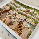 People sitting at a table with drinks and food on a boat, surrounded by palm trees and flowers.