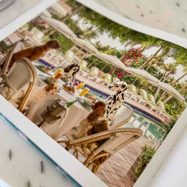 People sitting at a table with drinks and food on a boat, surrounded by palm trees and flowers.